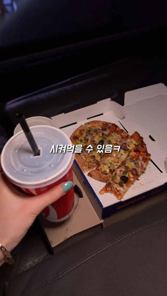 영화관 프라이빗 박스 좌석에서 피자와 음료를 즐기는 장면