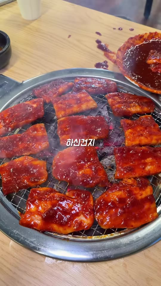 망원돈의 고추장삼겹살을 불판에서 굽는 장면
