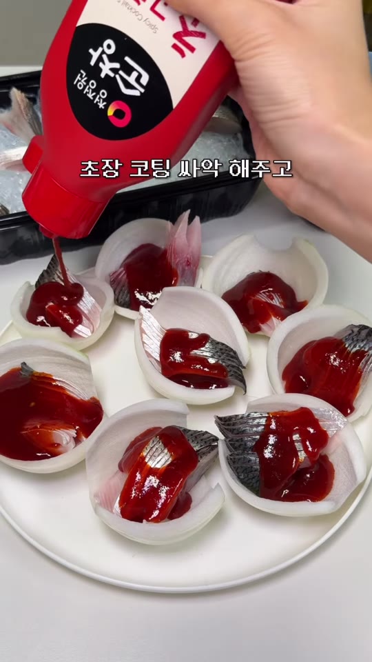 전어회 양파쌈에 소스를 곁들이는 장면
